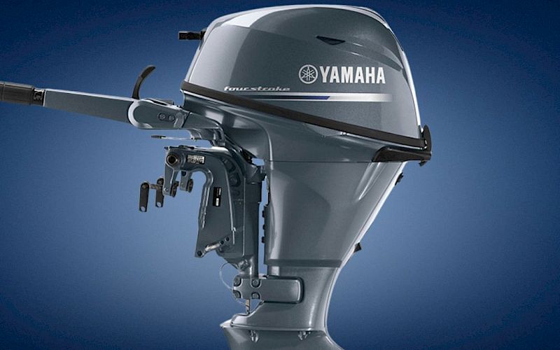 A silver Yamaha outboard boat motor is shown in close-up against a blue background.