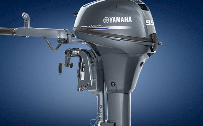 A close-up of a Yamaha 99 outboard boat motor against a dark blue background.