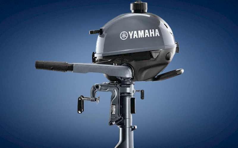 A Yamaha outboard boat motor with its housing and propeller shaft shown against a blue sky background.